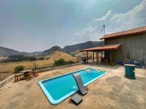 a swimming pool sitting on the side of a house at Estância Hidromineral Serra da Canastra - Delfinópolis MG in Delfinópolis