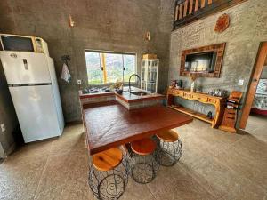a kitchen with a sink and a refrigerator at Estância Hidromineral Serra da Canastra - Delfinópolis MG in Delfinópolis