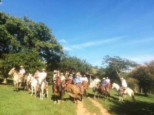 a group of people riding horses in a field at Estância Hidromineral Serra da Canastra - Delfinópolis MG in Delfinópolis