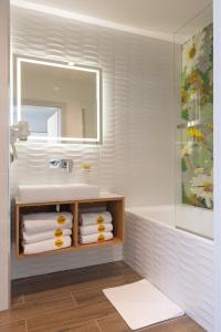 a bathroom with a sink and a mirror and towels at Miodowa Klinika in Kamianna