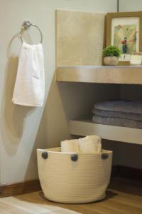 a bathroom with a basket of towels on a shelf at Blend Lodges in Tunuyán +26 photos