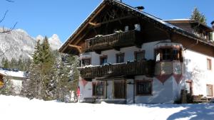 a building with a balcony in the snow at Neunerhof in Leutasch