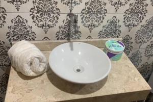 a bathroom with a white sink and a roll of toilet paper at Seasonal or student flat near Cachoeira in Campo Grande +5 photos