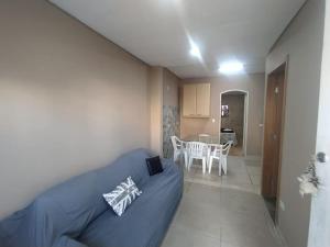 a bedroom with a blue bed and a dining room at Seasonal or student flat near Cachoeira in Campo Grande