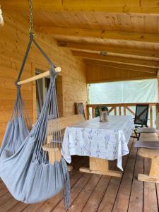 a room with a table and a hammock in a log cabin at Dom Na Wsi ,, Koszelówka " in Koszele