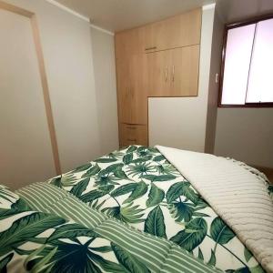 Un dormitorio con una cama con un edredón verde y blanco. en Casa Fior, en Puno 15 fotos más
