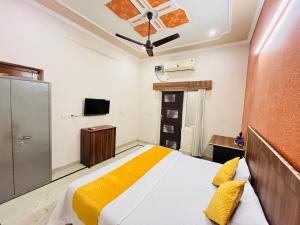 a bedroom with a bed and a tv at Krishna's Land Homestay in Vrindāvan