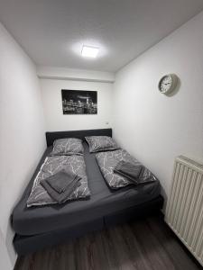 a bed in a small room with a clock on the wall at Ferienwohnung Hess in Rust
