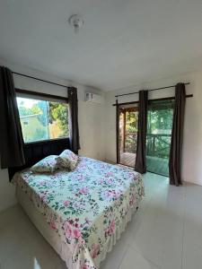 a bedroom with a bed and a large window at Pousada Encanto do Mutá in Marau