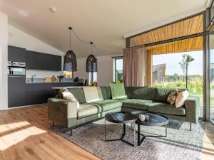 WissenkerkeにあるCottage near Het Bokkegat Nature Reserveの緑のソファとテーブルのあるリビングルーム