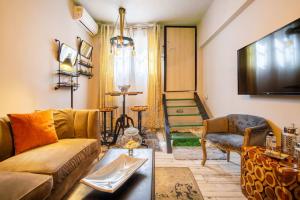 a living room with a couch and a tv at Diamond apartment in Athens