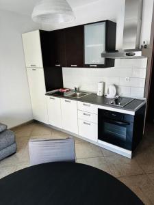 a kitchen with white cabinets and a sink and a stove at Apartments Vladimir in Malinska