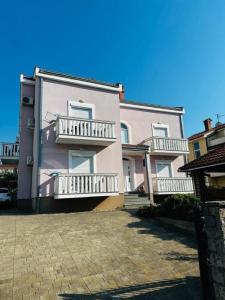 a large building with balconies on the side of it at Apartments Vladimir in Malinska