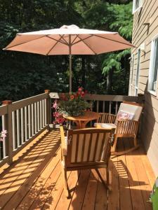 a wooden deck with a table and an umbrella at The Mountain House in Corvallis