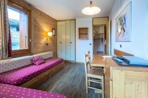 Cette chambre comprend un canapé, une table et un bureau. dans l'établissement Résidence Cristallin G - CRISTALLIN 1 MAE-2621, à Valmorel