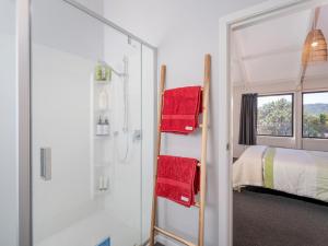 bagno con doccia, letto e specchio di Spacious Family Getaway - Whangamata Holiday Home a Whangamata Altre 37 foto