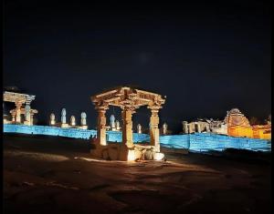 a group of columns in front of a building at night at Reddy home stay in Hampi