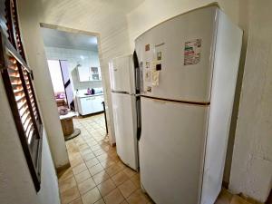 a kitchen with a white refrigerator and a tile floor at Casa Guio in Salvador
