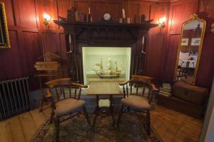 uma sala de jantar com uma mesa com um modelo de navio numa janela em 1777. At The Albion em Wimborne Minster