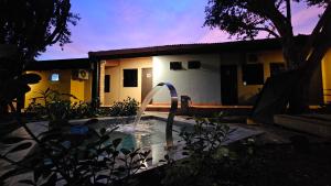 a pool with a water fountain in front of a house at Casa Alamanda - Posada Urbana in Ciudad del Este
