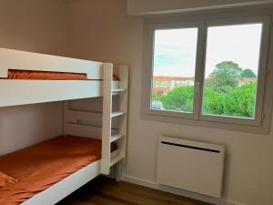 a room with two bunk beds and a window at Hyper Centre - Draps Inclus - Fibré - Parking - Local Vélos - Jusqu'à 6 personnes in Saint-Brevin-les-Pins