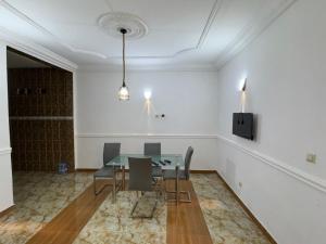 a dining room with a glass table and chairs at Complexe M Appartement meuble 3 chambres , 2 salles de bains une cuisine in Yaoundé