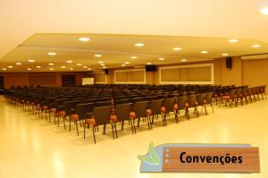 an empty lecture hall with chairs and a sign in the middle at Veredas - Rio Quente Reservas in Rio Quente +8 photos