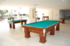 a pool table in a room with two tables at Veredas - Rio Quente Temporada in Rio Quente