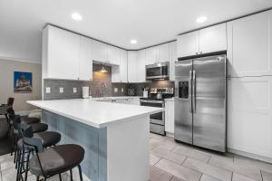 a kitchen with white cabinets and stainless steel appliances at Hillside Packers Haven by Simple Life Rentals in Green Bay