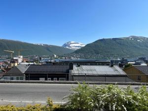 a city with mountains in the background and a street at Polar - TAG-apartments in Tromsø