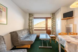 a living room with a couch and a table at Appartement Les Menuires in Les Menuires