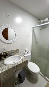 a bathroom with a sink and a toilet and a mirror at Lofts HOME Cabo Frio in Cabo Frio