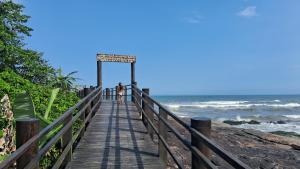 a boardwalk leading to the ocean on a beach at Loft Praia do Sonho in Itanhaém
