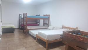 a room with three bunk beds in a room at Loft Praia do Sonho in Itanhaém