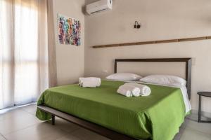 a bedroom with a green bed with towels on it at Borgo del Bambù in Perito +51 photos