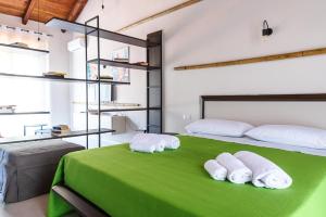 a bedroom with a green bed with two towels at Borgo del Bambù in Perito