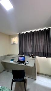 a desk with a laptop and a chair in a room at Lofts HOME Cabo Frio in Cabo Frio +10 photos