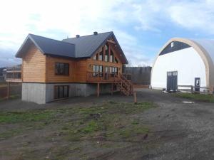 a large wooden house and a hangar at La Cabane aux Chevaux in Saint-Onésime