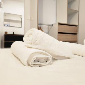 a white towel sitting on top of a bed at Le CoCon palois in Pau