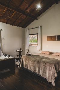 una camera da letto con un letto grande e una finestra di Chalé Alvorada Mirante Refúgio a Itamonte