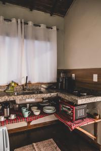 una cucina con piano di lavoro con pentole e padelle di Chalé Alvorada Mirante Refúgio a Itamonte