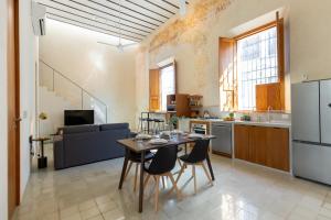 a kitchen and living room with a table and chairs at Departamentos Central by VIATO in Mérida