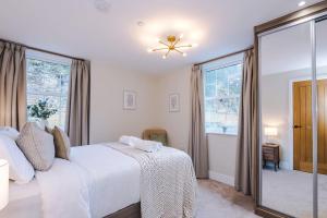 a bedroom with a white bed and a window at Rock Mill - Superior 2-Bedroom Apartment in Stoney Middleton