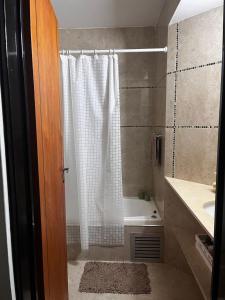 a bathroom with a shower curtain and a tub at Complejo Medanos in Costa Azul