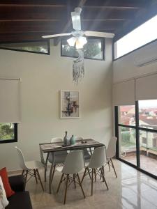 a dining room with a table and chairs and a ceiling fan at Complejo Medanos in Costa Azul