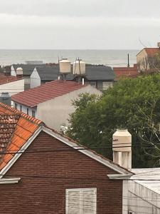 a view of roofs of houses and the ocean at Complejo Medanos in Costa Azul