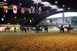a group of people riding horses in an arena at Cowboys Guest Ranch in Voghera
