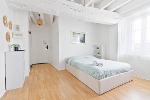 a white bedroom with a bed in a white room at Retraite Romantique à Étampes in Étampes
