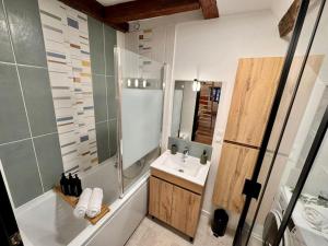 a bathroom with a tub and a sink and a shower at Grand studio, Cœur Historique ! in Châteauroux +12 photos