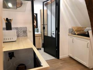 a kitchen with a black door and a counter top at Grand studio, Cœur Historique ! in Châteauroux